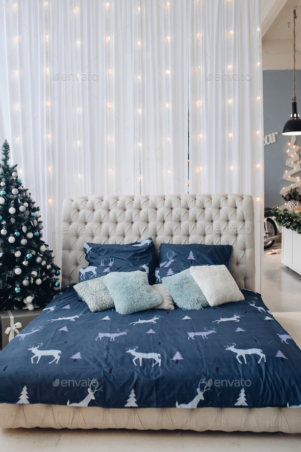 Tidy bed with Christmas tree and garland - Stock Photo - Images