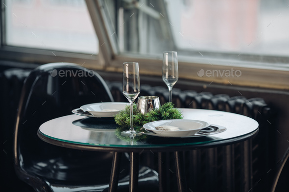 Romantic dinner for two at Christmas. plates against classic sofa in modern apartment - Stock Photo - Images