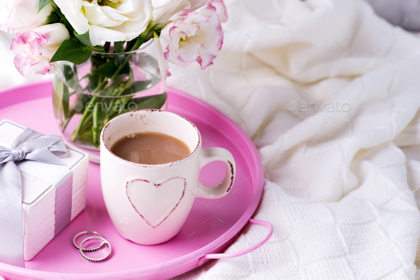 A tray with a cup of coffee, gift box, flowers and rings on the bed. Valentine's Day Wedding - Stock Photo - Images