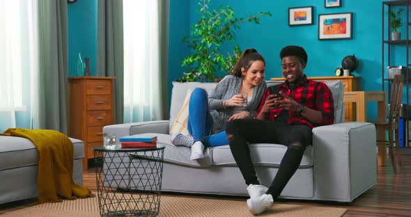 Nice Lovely African American Joyful Married Family Couple Man and Woman Sitting on Sofa Resting alt