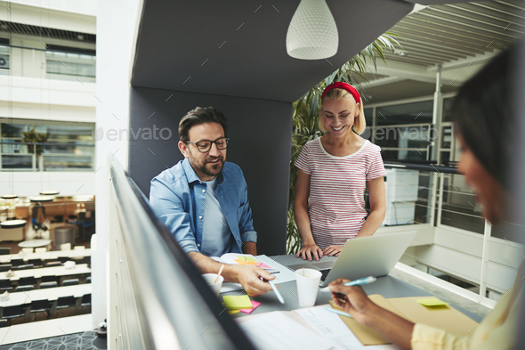 Smiling diverse businesspeople working in an office meeting pod - Stock Photo - Images