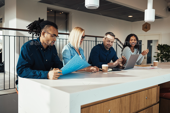 Smiling group of businesspeople discussing work during an office meeting - Stock Photo - Images