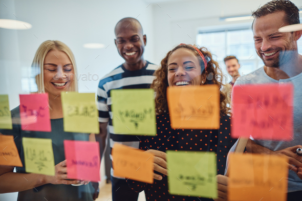 Laughing group of designers brainstorming together in an office - Stock Photo - Images