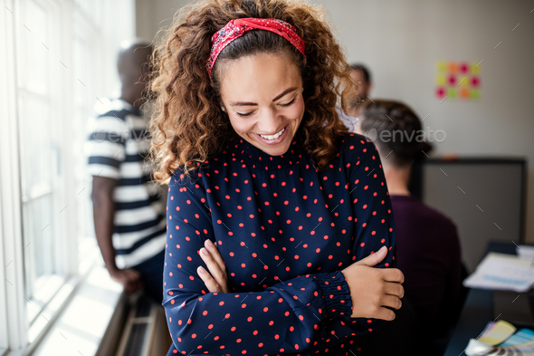 Young designer laughing with colleagues in the background - Stock Photo - Images