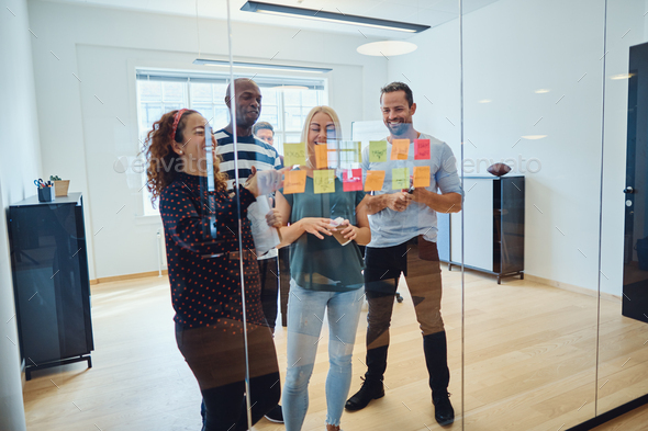 Designers smiling during an office brainstorming session - Stock Photo - Images