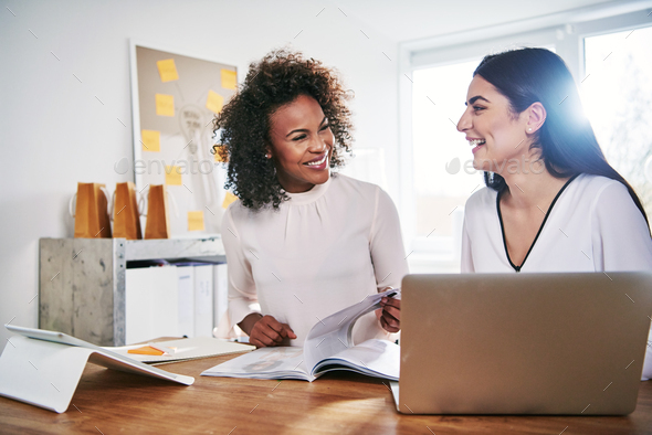 Two happy businesswomen laughing together - Stock Photo - Images