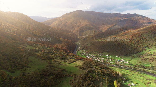 mountain village buildings at river against brown hillpeaks - Stock Photo - Images