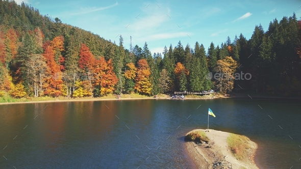 tourists wander along lake sandy bank by mixed forests - Stock Photo - Images