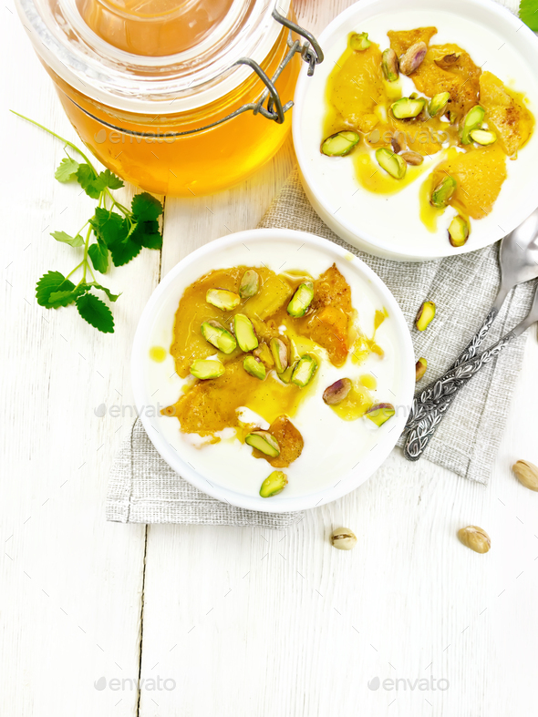 Dessert of yogurt and persimmon two bowls on light board top - Stock Photo - Images