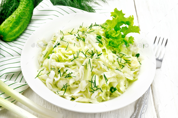 Salad of cabbage and cucumber in plate on white board - Stock Photo - Images