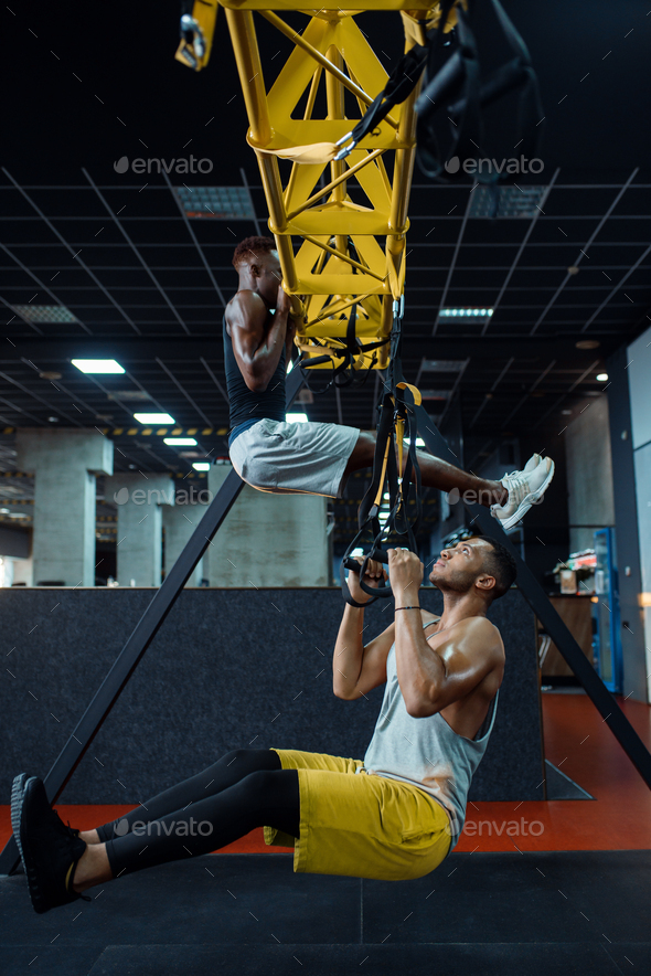 Muscular athlete at stretching exercise machine - Stock Photo - Images
