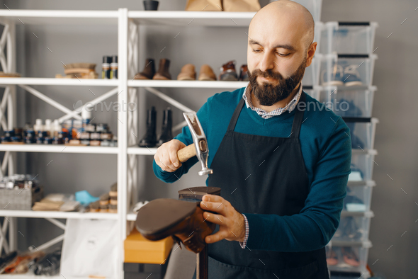 Shoemaker knocks the heel, shoe repair service - Stock Photo - Images