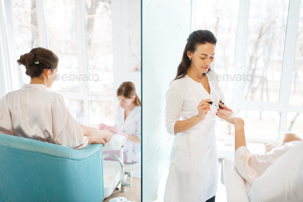 Manicure masters applies nail polish to woman - Stock Photo - Images