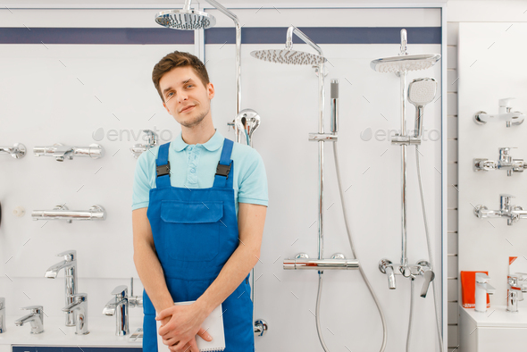 Plumber at showcase with boilers, plumbering store - Stock Photo - Images