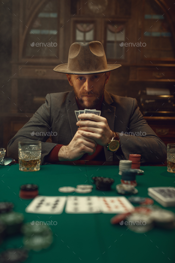 Poker player in suit and hat plays in casino - Stock Photo - Images