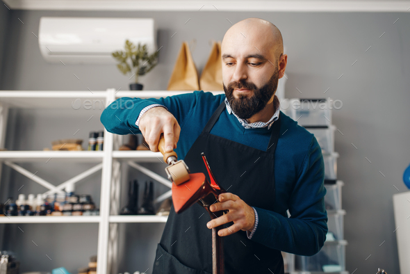Shoemaker repairing shoe, footwear repair service - Stock Photo - Images