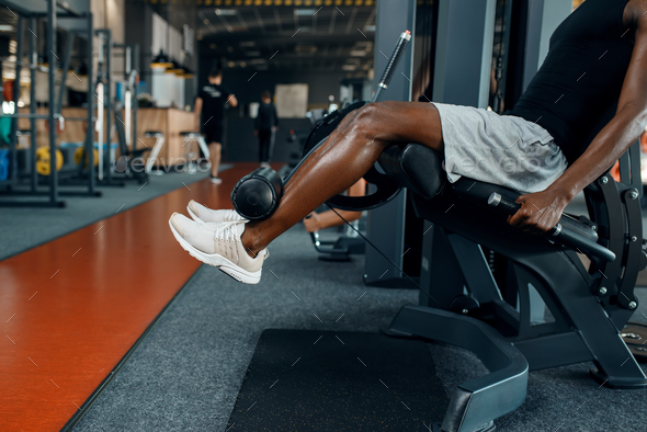 Muscular athlete in sportswear at exercise machine - Stock Photo - Images