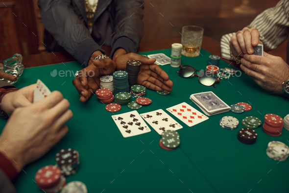 Poker players hands, gaming table on background - Stock Photo - Images