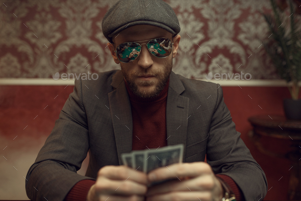 Serious poker player playing in casino - Stock Photo - Images