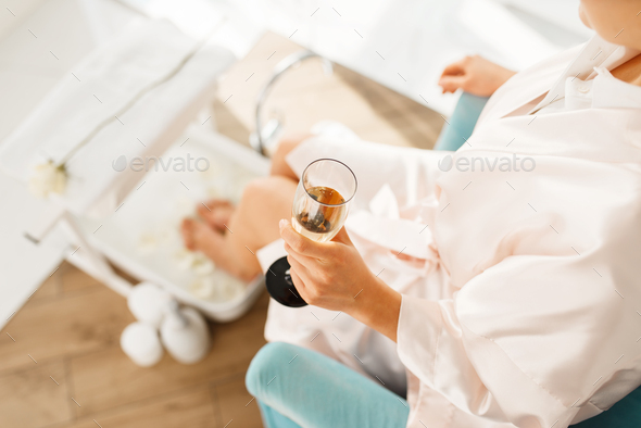 Woman uses a foot bath and drinks champagne - Stock Photo - Images