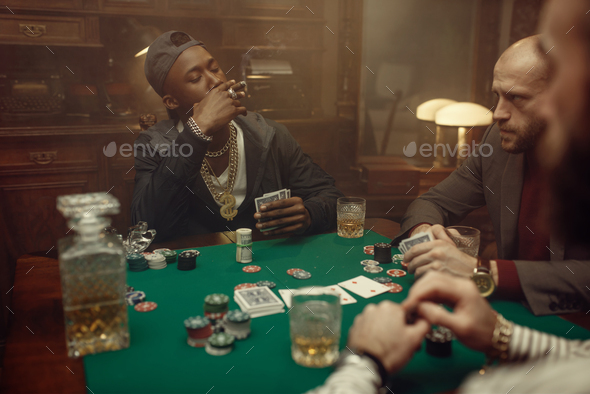 Poker players at gaming table with green cloth - Stock Photo - Images