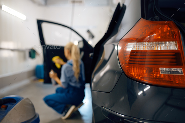 Female washer cleans automobile door trim - Stock Photo - Images