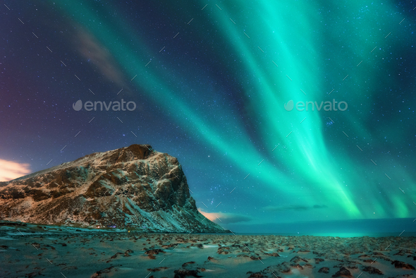 Aurora borealis above the snowy mountains and sandy beach - Stock Photo - Images