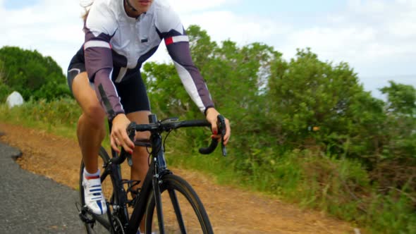 Female cyclist cycling on a countryside road alt