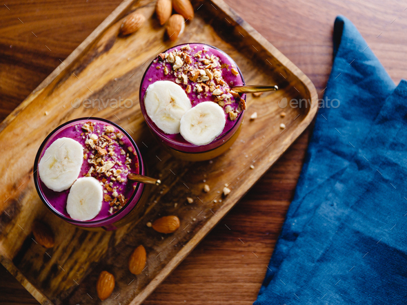 Top view of two glasses with violet berry and banana smoothie - Stock Photo - Images