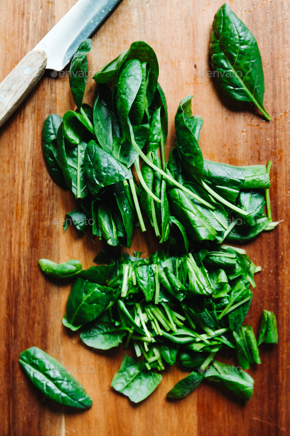 Top view of fresh spinach leaves on a wooden cutting board - Stock Photo - Images