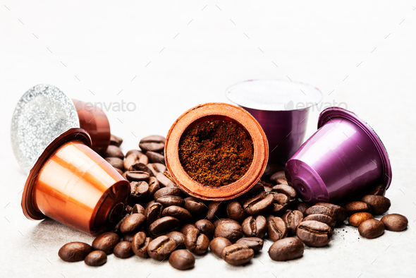 Espresso coffee capsules or pods and coffee beans on grey background - Stock Photo - Images