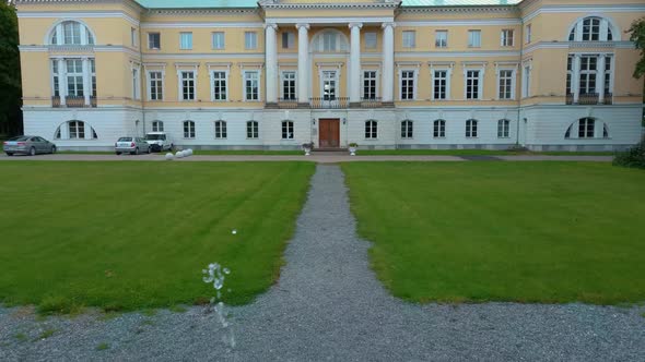 Mezotne Palace and Park With Fountain in Latvia. Lielupe River With Ponton Bridge Aerial 4K alt