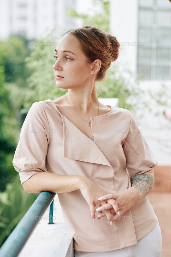Pensive woman standing on balcony - Stock Photo - Images