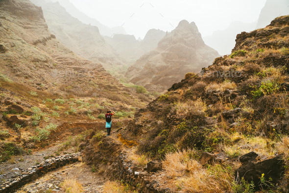 Traveler on great walking destination with stunning views of rugged coast lines and narrow canyons - Stock Photo - Images