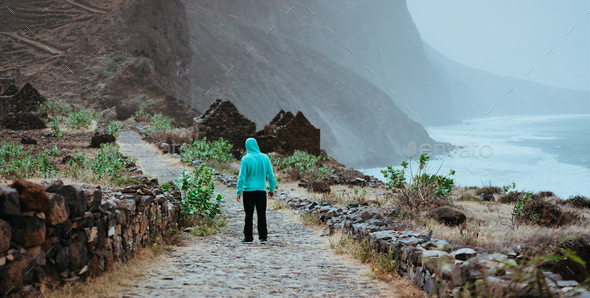 Male hiker admiring beautiful dramatic landscape of rugged coastline on the trekking trail to - Stock Photo - Images