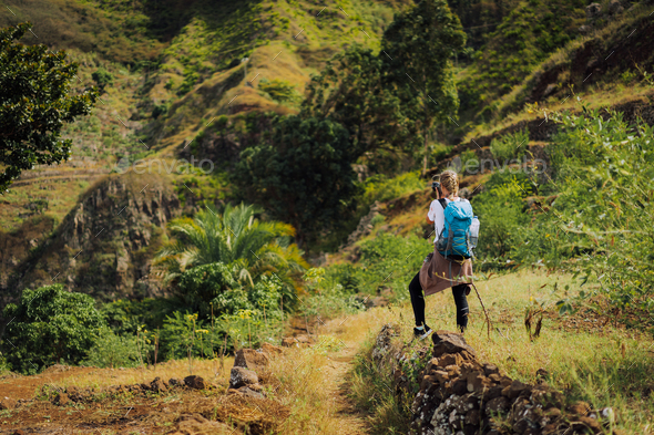 Woman tourist with blue backpack making photo of landscape in Mountains of Santo Antao island, Cabo - Stock Photo - Images