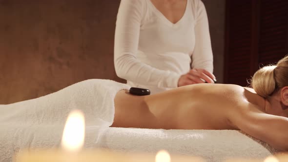 Young, healthy and beautiful woman gets massage therapy in the spa salon. alt