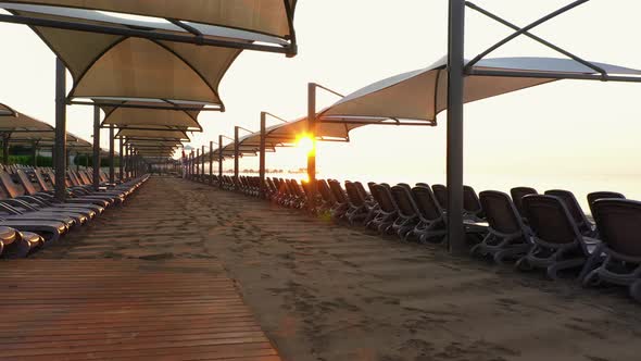 Beach Sunbeds and Umbrellas at Sunset. alt