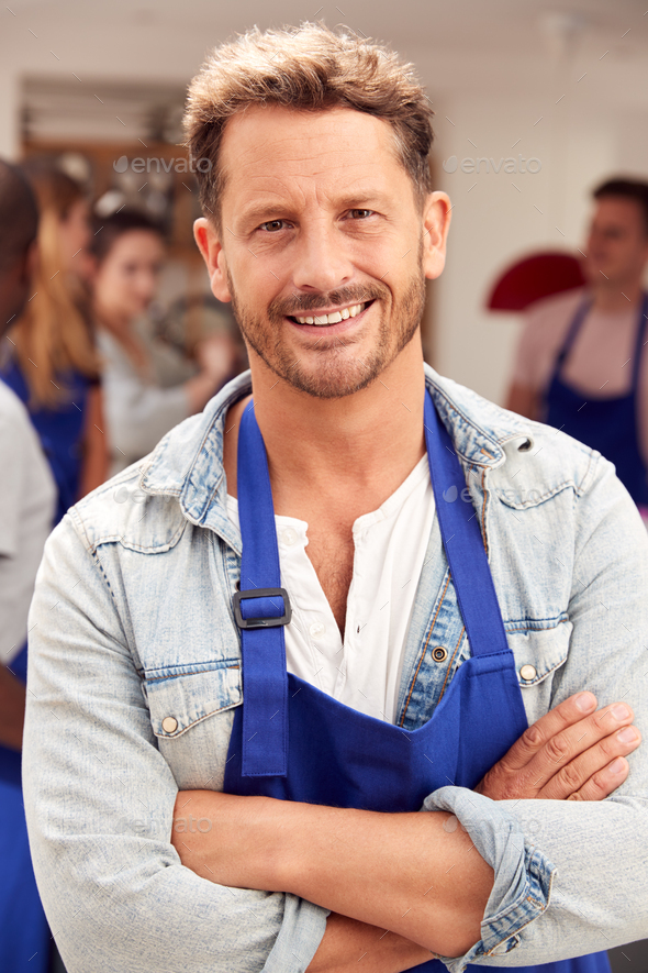 Download Portrait Of Smiling Mature Man Wearing Apron Taking Part In Cookery Class In Kitchen Stock Photo ...