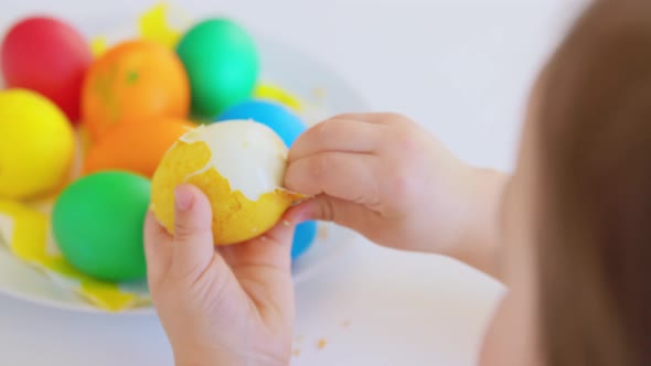 Baby Girl Peeling Easter Egg From Shell at Home