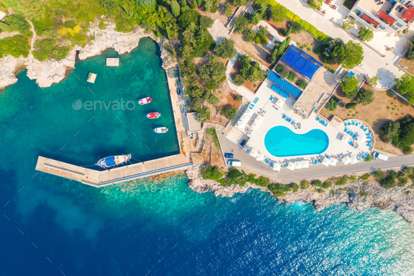 Aerial view of sea coast with clear blue water, boats and pool - Stock Photo - Images
