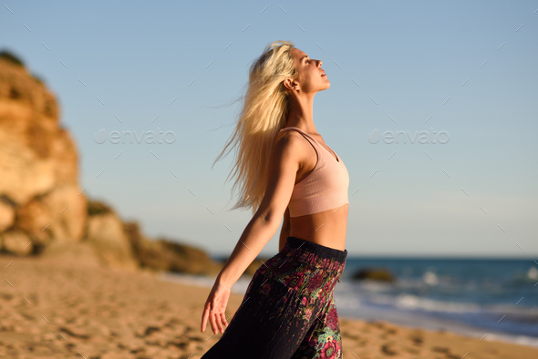 Woman enjoying the sunset on a beautiful beach - Stock Photo - Images