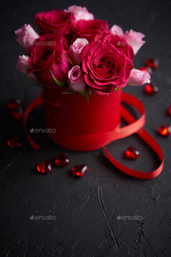 Pink roses bouquet packed in red box and placed on black stone background - Stock Photo - Images