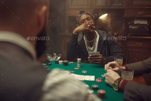 Poker players at gaming table with green cloth - Stock Photo - Images