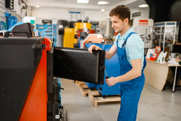 Plumber choosing boiler with furnace, plumbering - Stock Photo - Images