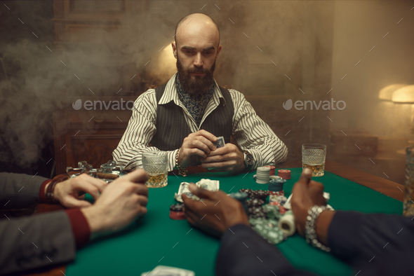 Poker players with cards and chips in casino - Stock Photo - Images