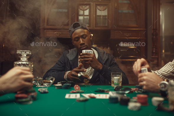 Poker players at gaming table with bets, casino - Stock Photo - Images