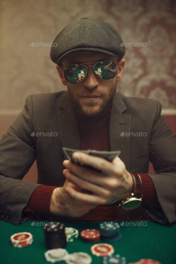 Serious poker player playing in casino - Stock Photo - Images