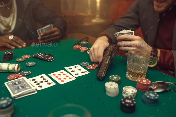 Poker player with gun plays in casino, risk