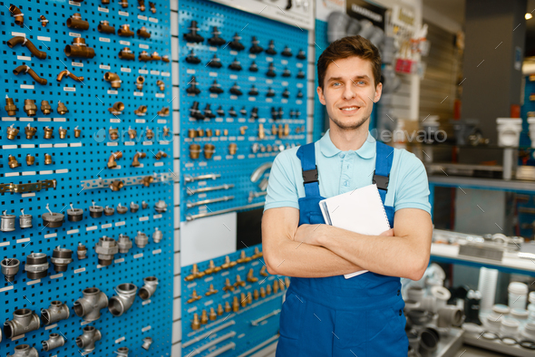 Plumber at showcase with valves and pipe adapters - Stock Photo - Images